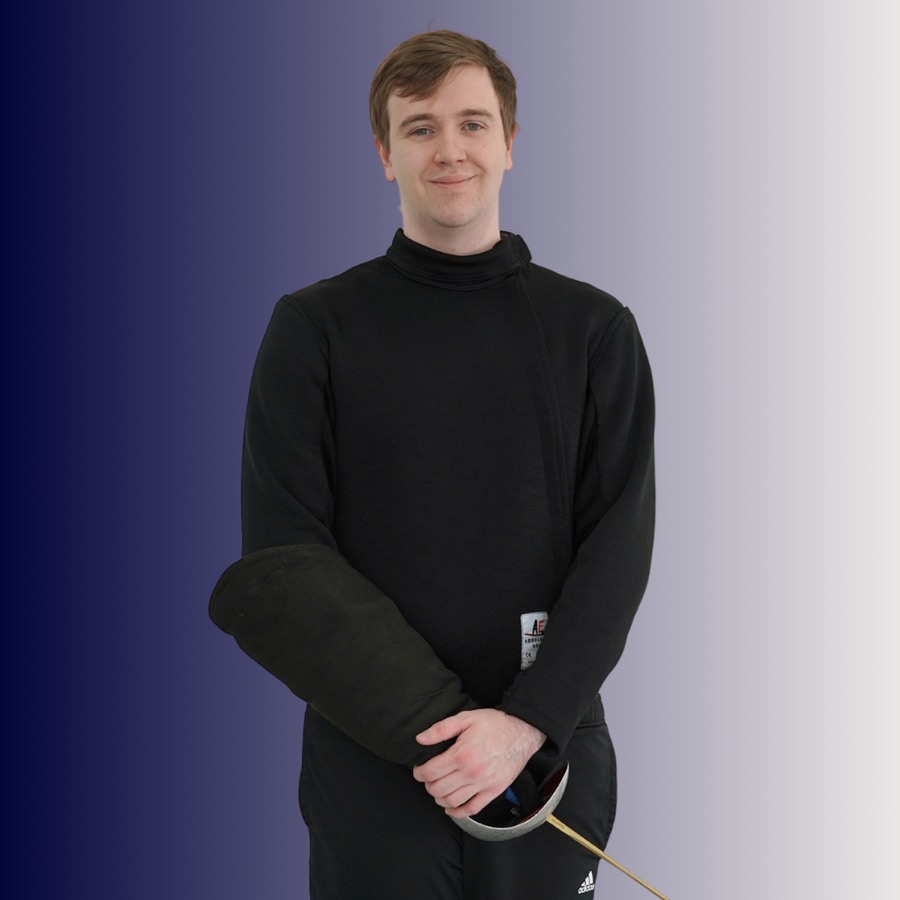 Young man in black fencing gear standing with a fencing epee.